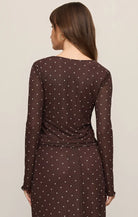 Brown mesh long-sleeve top with white polka dots, featuring a V-neckline, delicate front ties, and a slightly sheer fitted design.
