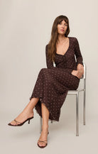 Brown mesh midi skirt with white polka dots, featuring a high-rise elastic waistband, lettuce-edge hem, and fully lined silhouette.
