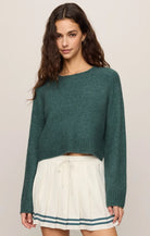 Cropped knit sweater in a soft, lightweight yarn, featuring a relaxed raglan silhouette, crew neckline, and long sleeves. Colour forest green.