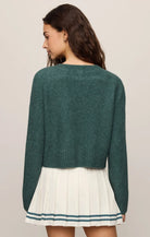 Cropped knit sweater in a soft, lightweight yarn, featuring a relaxed raglan silhouette, crew neckline, and long sleeves. Colour forest green.