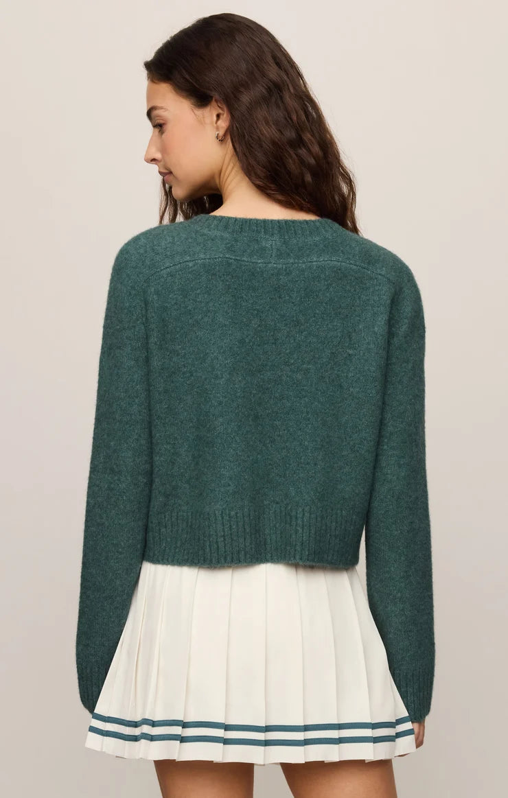 Cropped knit sweater in a soft, lightweight yarn, featuring a relaxed raglan silhouette, crew neckline, and long sleeves. Colour forest green.