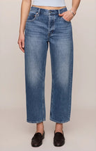 Vintage-wash blue mid-rise jeans featuring a relaxed bowed-leg silhouette, ankle-length hem, and classic five-pocket styling.
