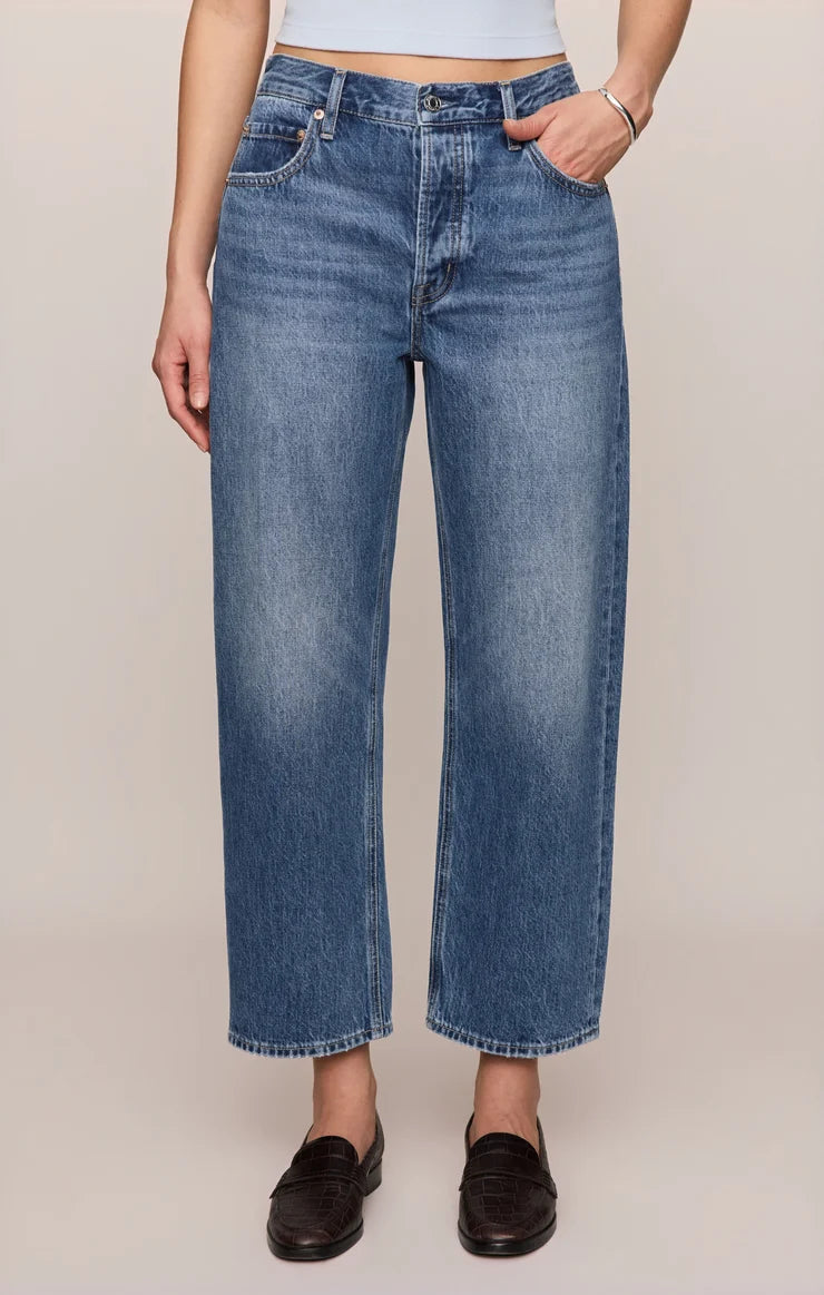 Vintage-wash blue mid-rise jeans featuring a relaxed bowed-leg silhouette, ankle-length hem, and classic five-pocket styling.
