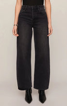 High-rise washed black jeans featuring a relaxed bowed-leg silhouette, full-length hem, and contrast whipstitch detailing inside the cuff.