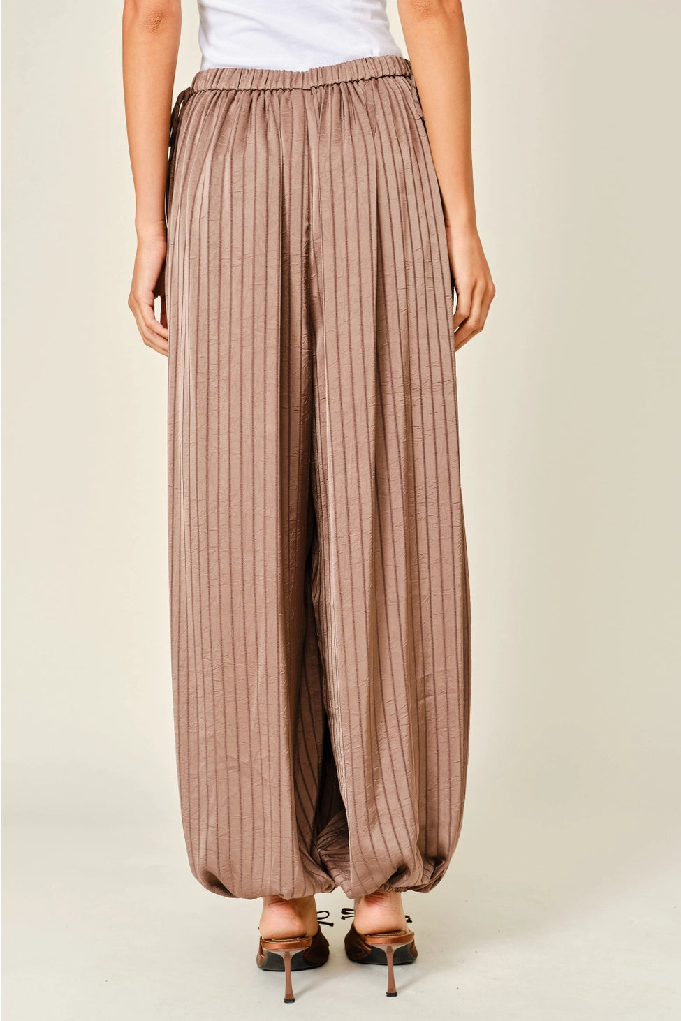 Zola Striped Satin Bubble Pants featuring a soft, glossy satin finish with a striped pattern, comfortable elastic waistband, adjustable drawstring side details, and functional side pockets. Designed with a relaxed, voluminous balloon silhouette and a flowy, lightweight feel for an effortlessly chic look.