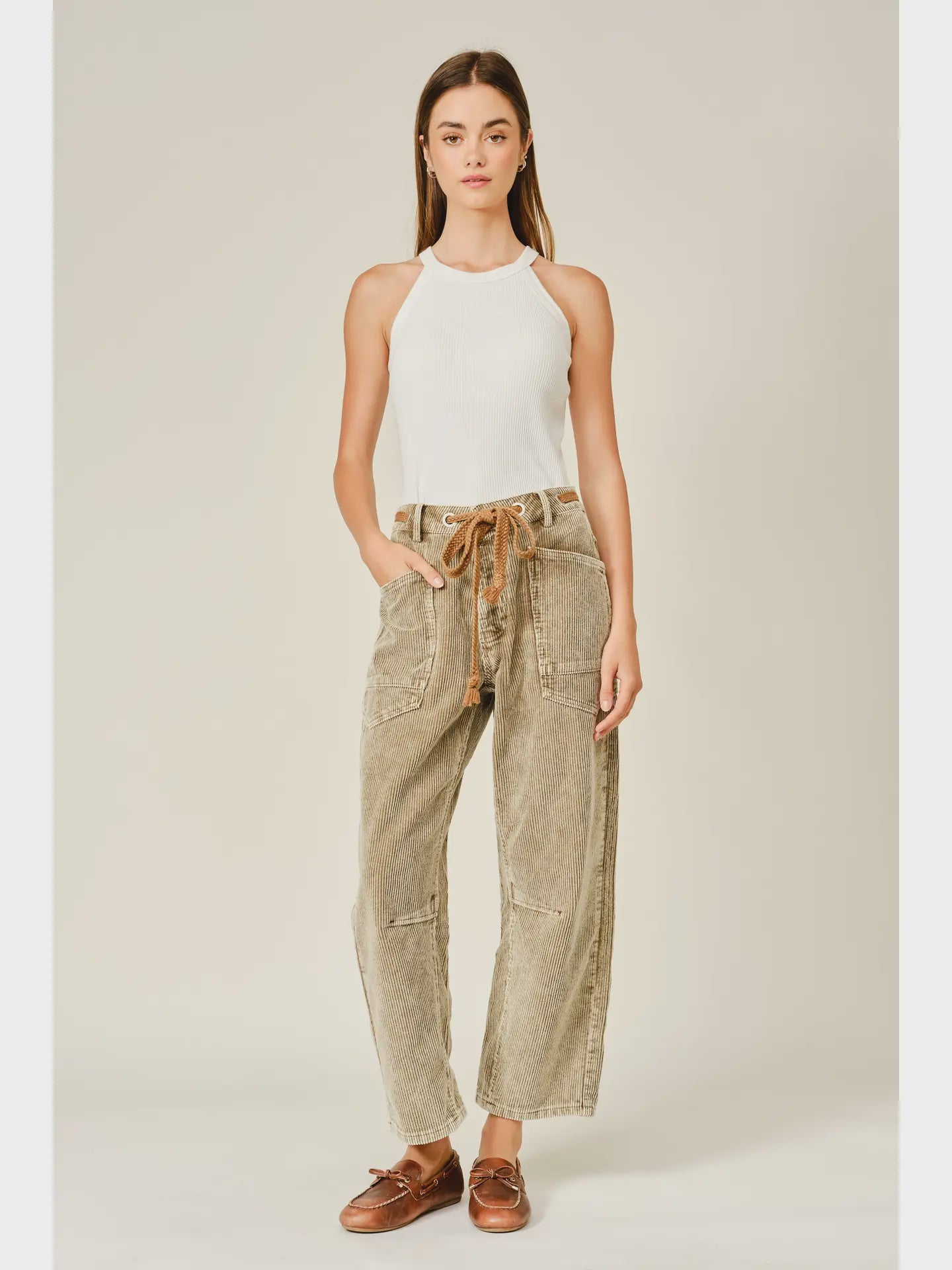 Women’s camel corduroy trousers featuring a subtle barrel fit, utility patch pockets, belt loops, and a rope tie waist.