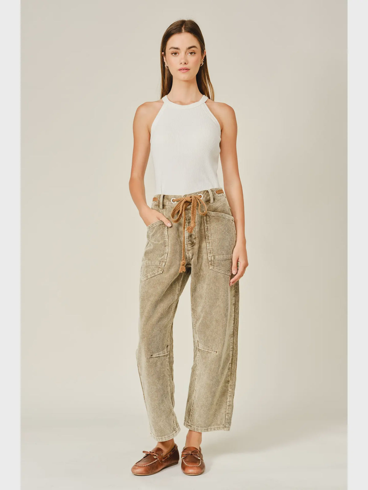 Women’s camel corduroy trousers featuring a subtle barrel fit, utility patch pockets, belt loops, and a rope tie waist.