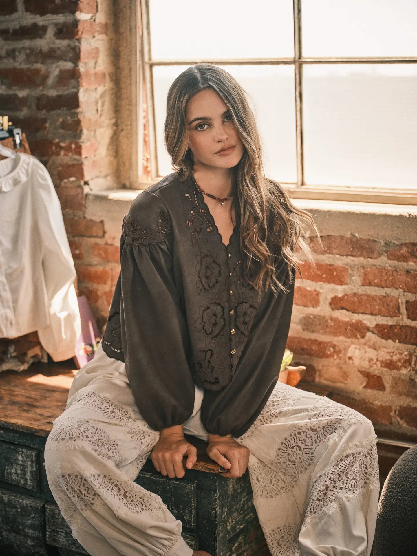 Women’s brown boho blouse featuring tonal floral embroidery, scalloped V-neckline, button-front closure, and relaxed long balloon sleeves.