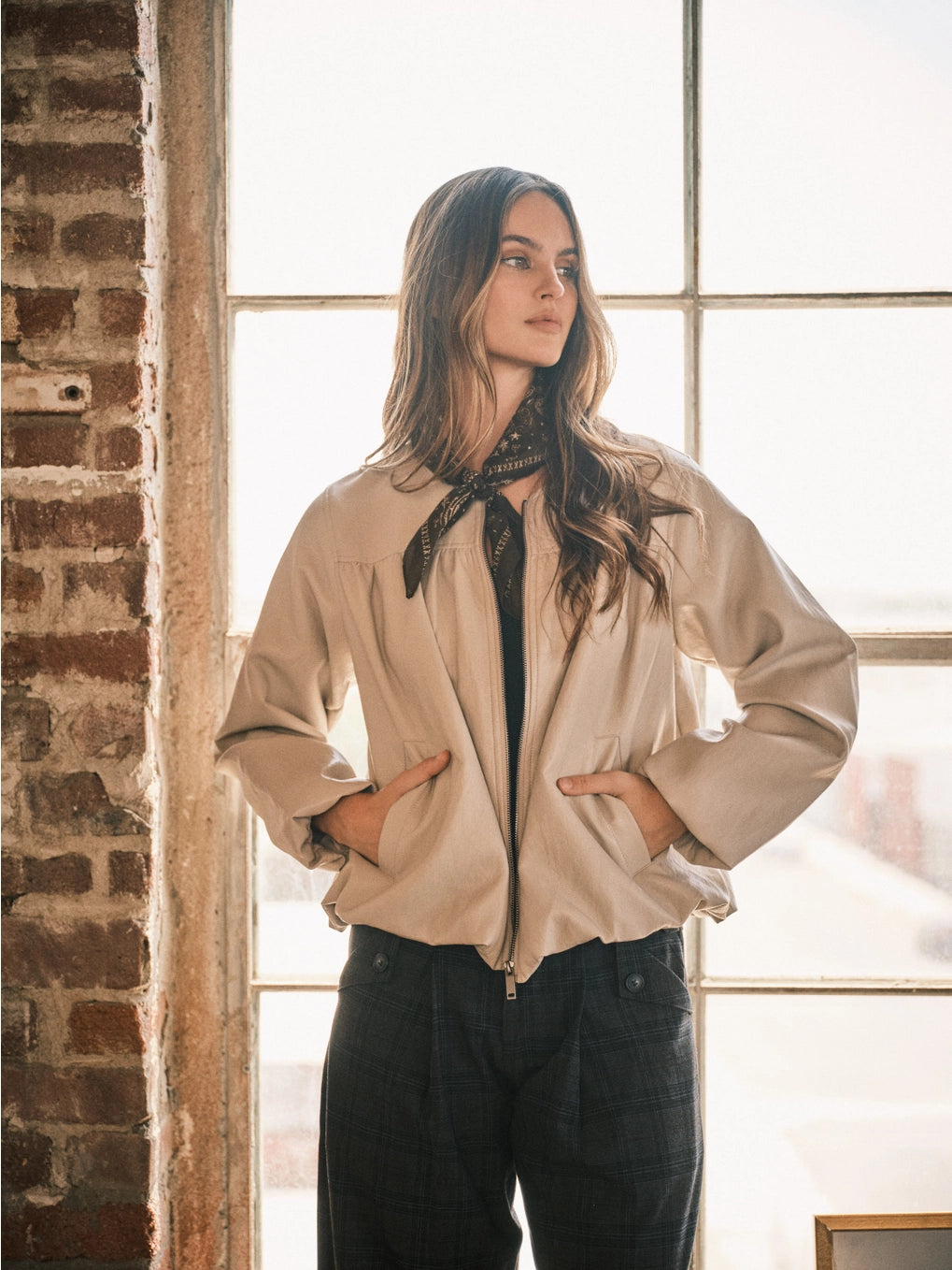 Women’s dove bomber jacket featuring a relaxed fit, zip-front closure, voluminous long sleeves, side pockets, and gathered hem detailing.
