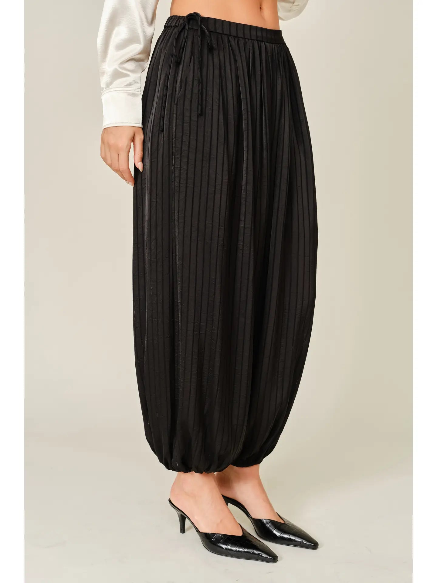 Zola Striped Satin Bubble Pants featuring a soft, glossy satin finish with a striped pattern, comfortable elastic waistband, adjustable drawstring side details, and functional side pockets. Designed with a relaxed, voluminous balloon silhouette and a flowy, lightweight feel for an effortlessly chic look.