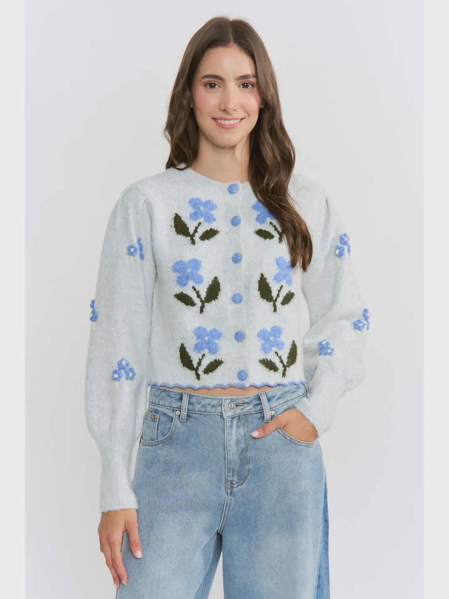 The Amelie Floral Cardigan in light grey with delicate blue floral embroidery and green stem details.
