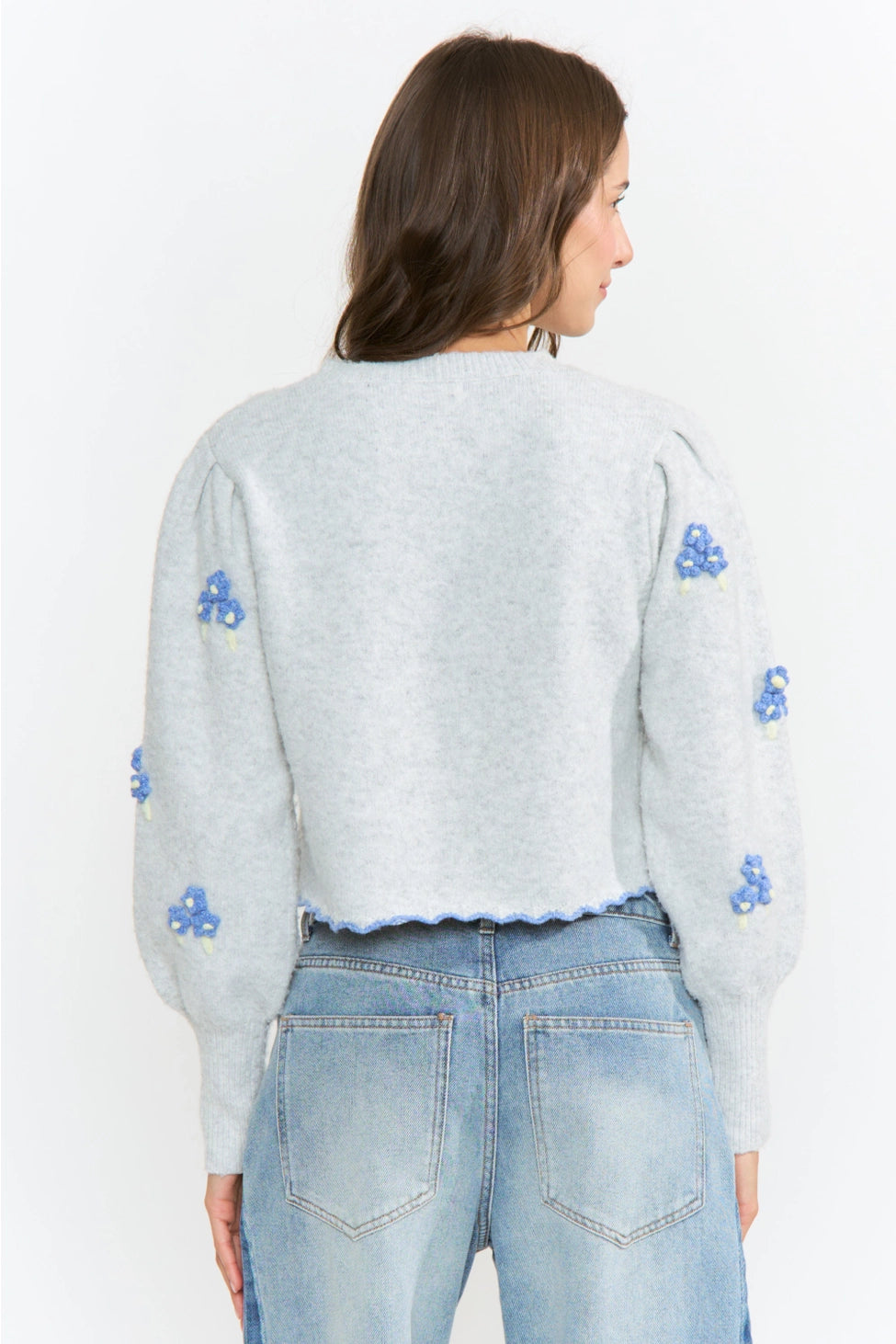 The Amelie Floral Cardigan in light grey with delicate blue floral embroidery and green stem details.
