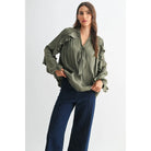 The Juliette Ruffle Blouse in olive green, featuring delicate ruffle detailing and a soft, silky finish.

