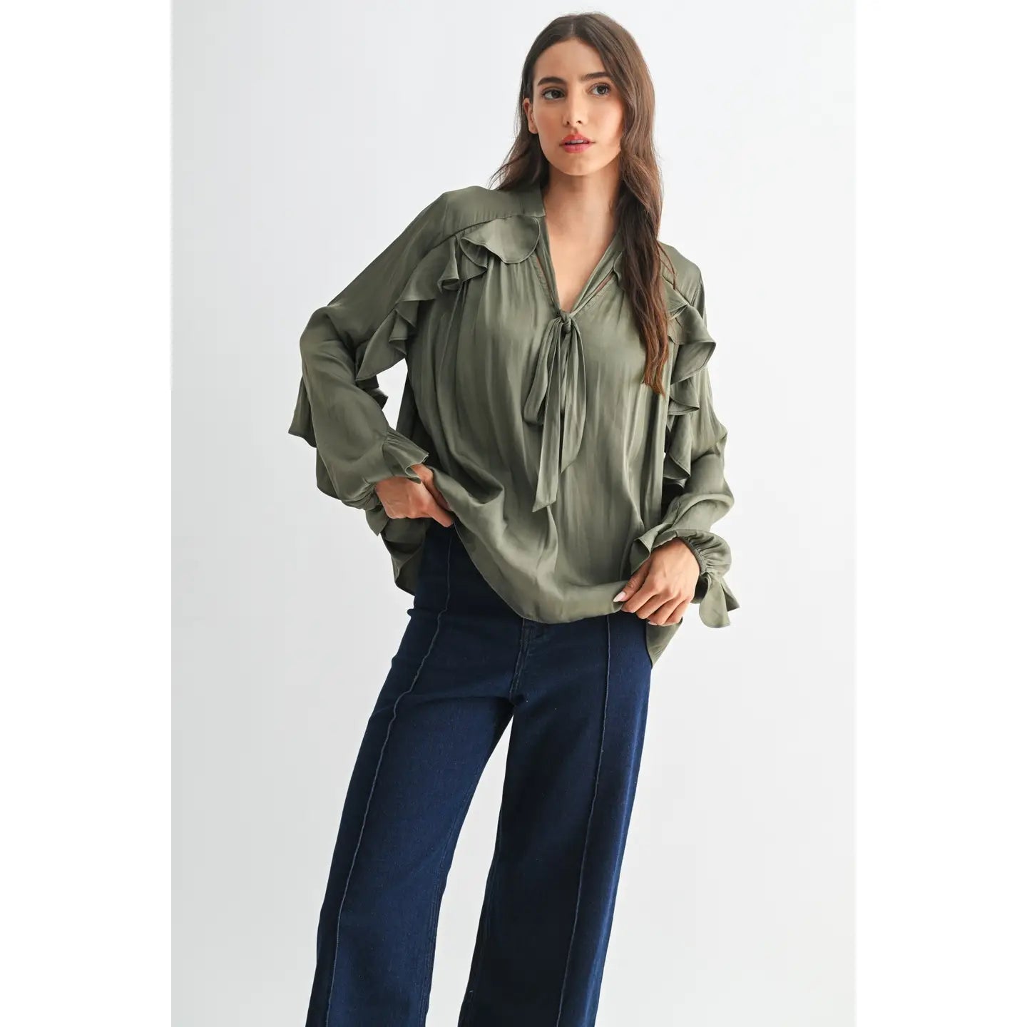 The Juliette Ruffle Blouse in olive green, featuring delicate ruffle detailing and a soft, silky finish.
