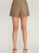 Clara Lace Trim Shorts featuring a smooth faux leather finish, flattering high-waisted silhouette, and delicate lace trim along the hem. Designed with a chic, feminine fit and edgy detailing. Pairs perfectly with the matching Clara Lace Trim Button-Down Top for a coordinated look.