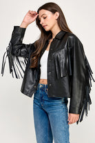 The Dakota Fringe Jacket in black faux leather, featuring bold fringe detailing and a structured silhouette with Western-inspired styling.
