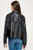 The Dakota Fringe Jacket in black faux leather, featuring bold fringe detailing and a structured silhouette with Western-inspired styling.
