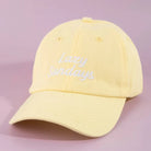 A pale yellow cotton baseball cap with 'Lazy Sundays' embroidered in white script on the front