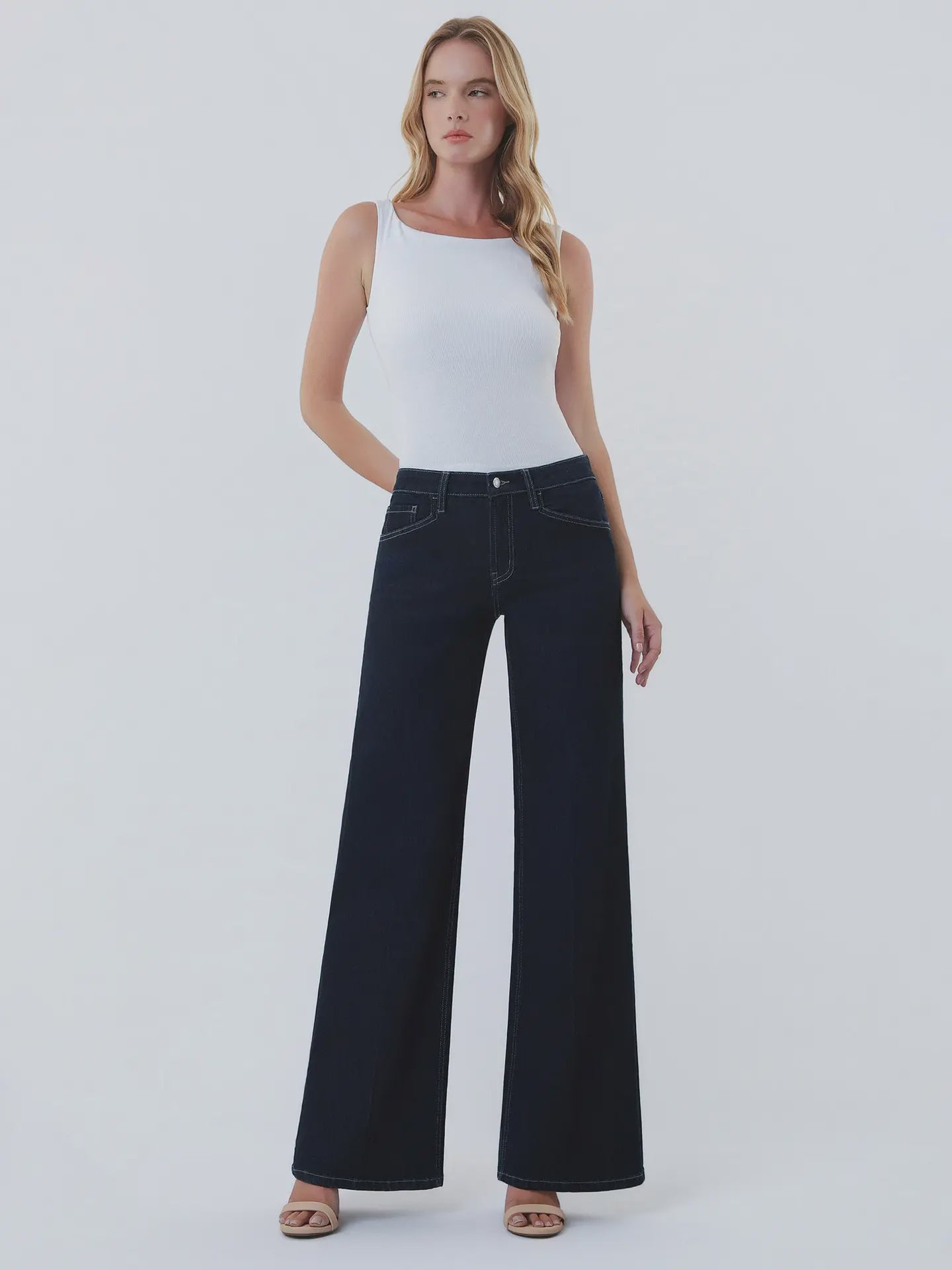 Dark wash wide-leg jeans featuring a mid-rise waist, trouser-inspired front crease, classic five-pocket design, finished hem, and full-length silhouette.