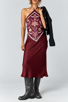 Satin midi dress with an adjustable halter neckline, fit-and-flare silhouette, handkerchief-style bodice, strapless design, and open back. Finished with a smooth satin fabrication and easy pull-on construction.