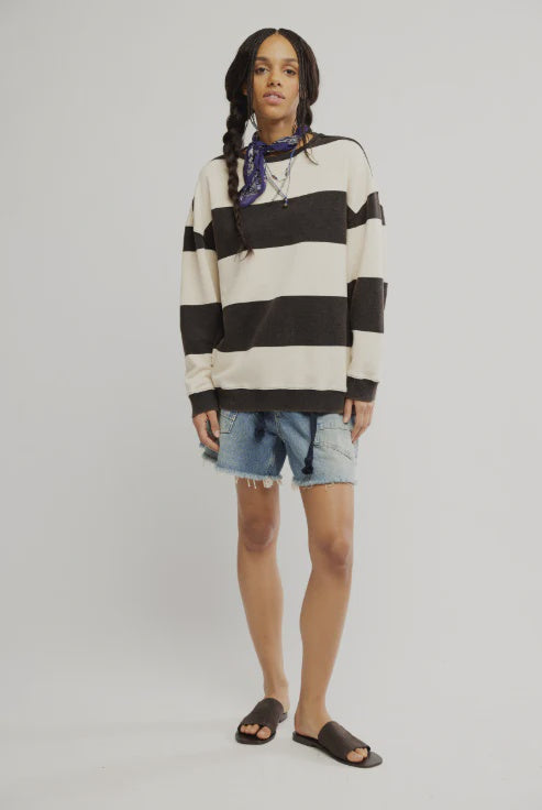 woman wearing a black and off white striped oversized crewneck sweater