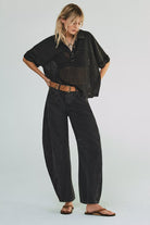woman wearing washed black mid rise barrel jeans in an ankle length