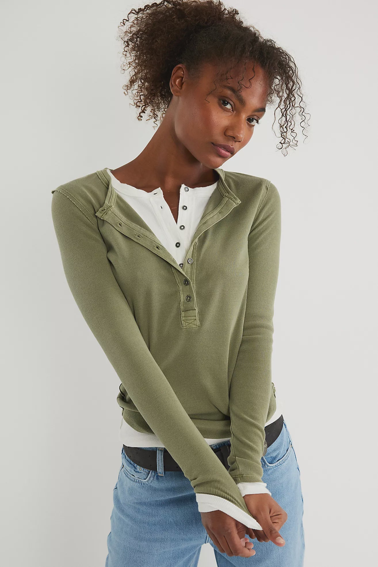 Woman wearing a green long-sleeve henley shirt with a half button down v neck