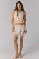 woman wearing satin a line mini skirt with a lace hem. Ivory / cream colour