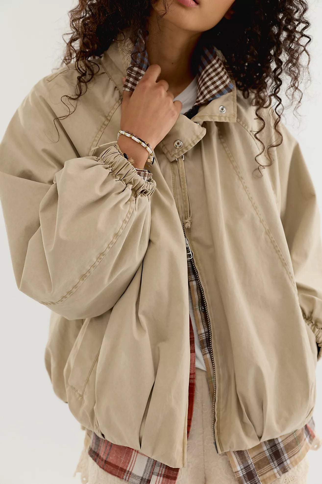 Free People Chelsea Funnel Neck Jacket in Oatmeal featuring an oversized slouchy fit, lightweight cotton-blend fabric, funnel-neck collar, raglan sleeves, adjustable drawcord waist, front zipper closure, and side slit pockets.