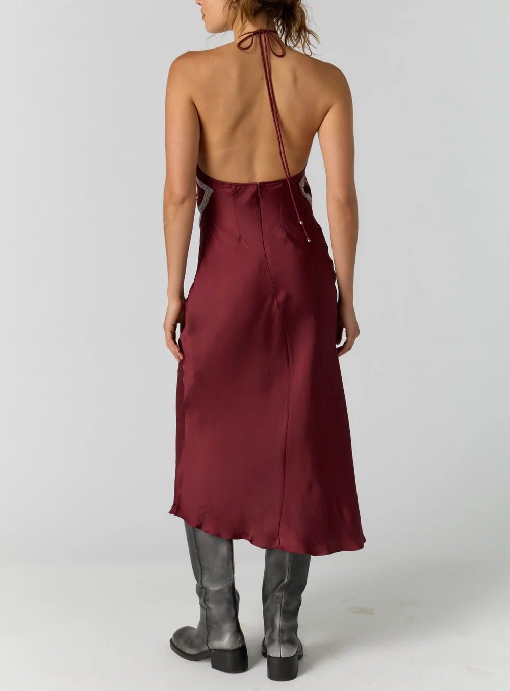 Satin midi dress with an adjustable halter neckline, fit-and-flare silhouette, handkerchief-style bodice, strapless design, and open back. Finished with a smooth satin fabrication and easy pull-on construction.
