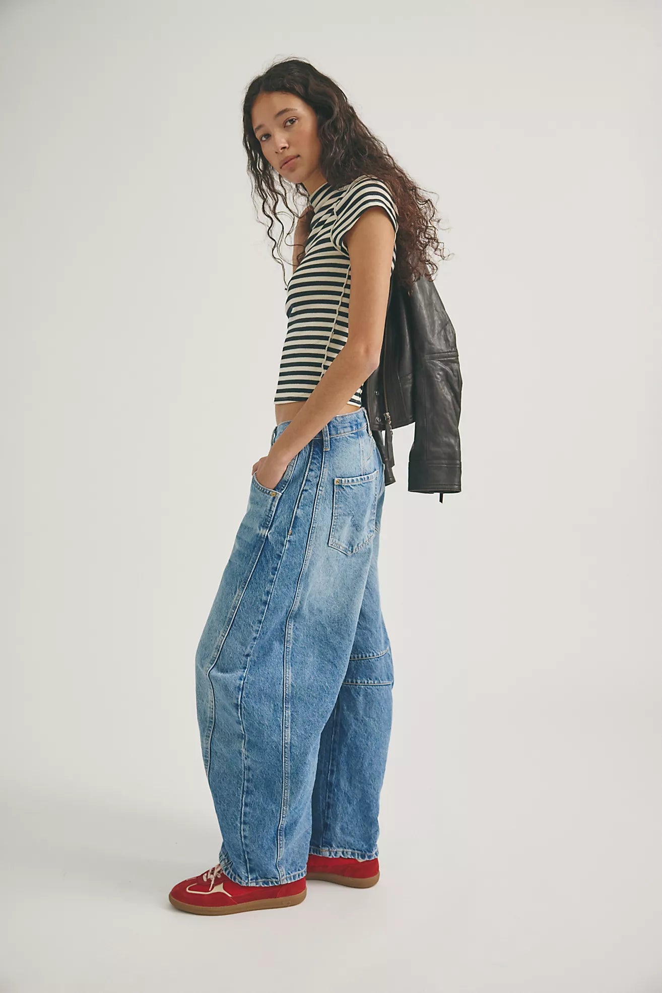 woman wearing mid rise barrel jeans in a mid wash that are ankle length