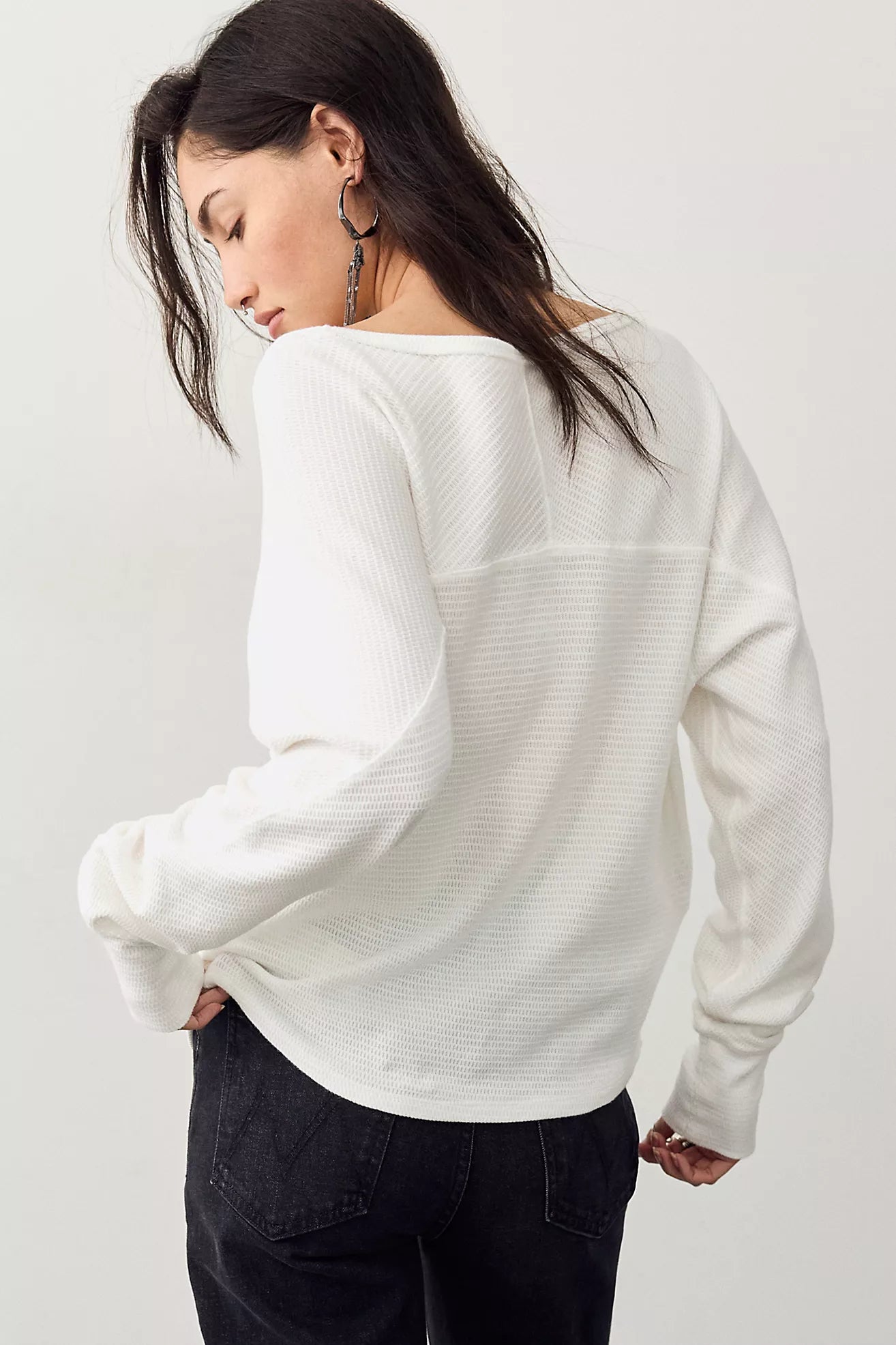 Thermal long-sleeve top featuring a flattering boat neckline, relaxed dolman sleeves, textured cotton-blend fabrication, seamed detailing, and elongated cuffs.