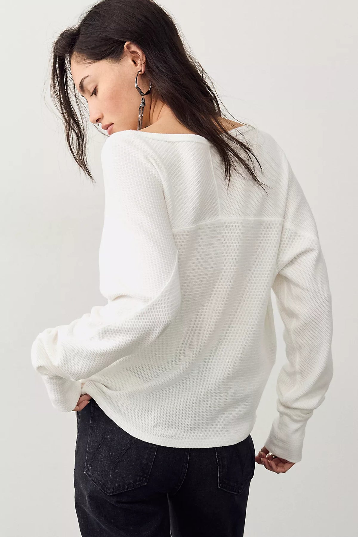 Thermal long-sleeve top featuring a flattering boat neckline, relaxed dolman sleeves, textured cotton-blend fabrication, seamed detailing, and elongated cuffs.