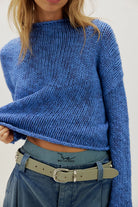 Peri Blue cotton knit sweater with a relaxed boxy fit, rolled neckline, dropped shoulders, and long sleeves.
