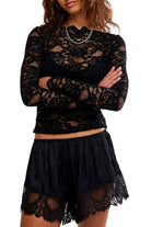 Sheer floral lace long-sleeve top with a fitted silhouette, boat neckline, ribbed trim, and added stretch for a comfortable, body-skimming fit. Base layer sold separately.