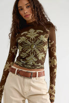 Free People Jessa Long Sleeve Top in Olive Combo featuring a fitted silhouette, semi-sheer mesh fabric, high turtleneck, long sleeves, intricate olive and cream ornamental print, and keyhole detail at the back.