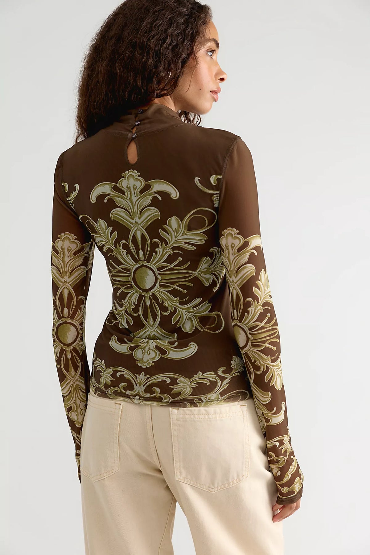 Free People Jessa Long Sleeve Top in Olive Combo featuring a fitted silhouette, semi-sheer mesh fabric, high turtleneck, long sleeves, intricate olive and cream ornamental print, and keyhole detail at the back.