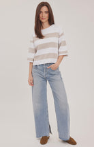 Woman wearing the Gentle Fawn Amina Knit Top in Heather Cream Stripe, featuring a relaxed fit, crew neckline, rolled hem details, and soft beige and cream horizontal stripes.