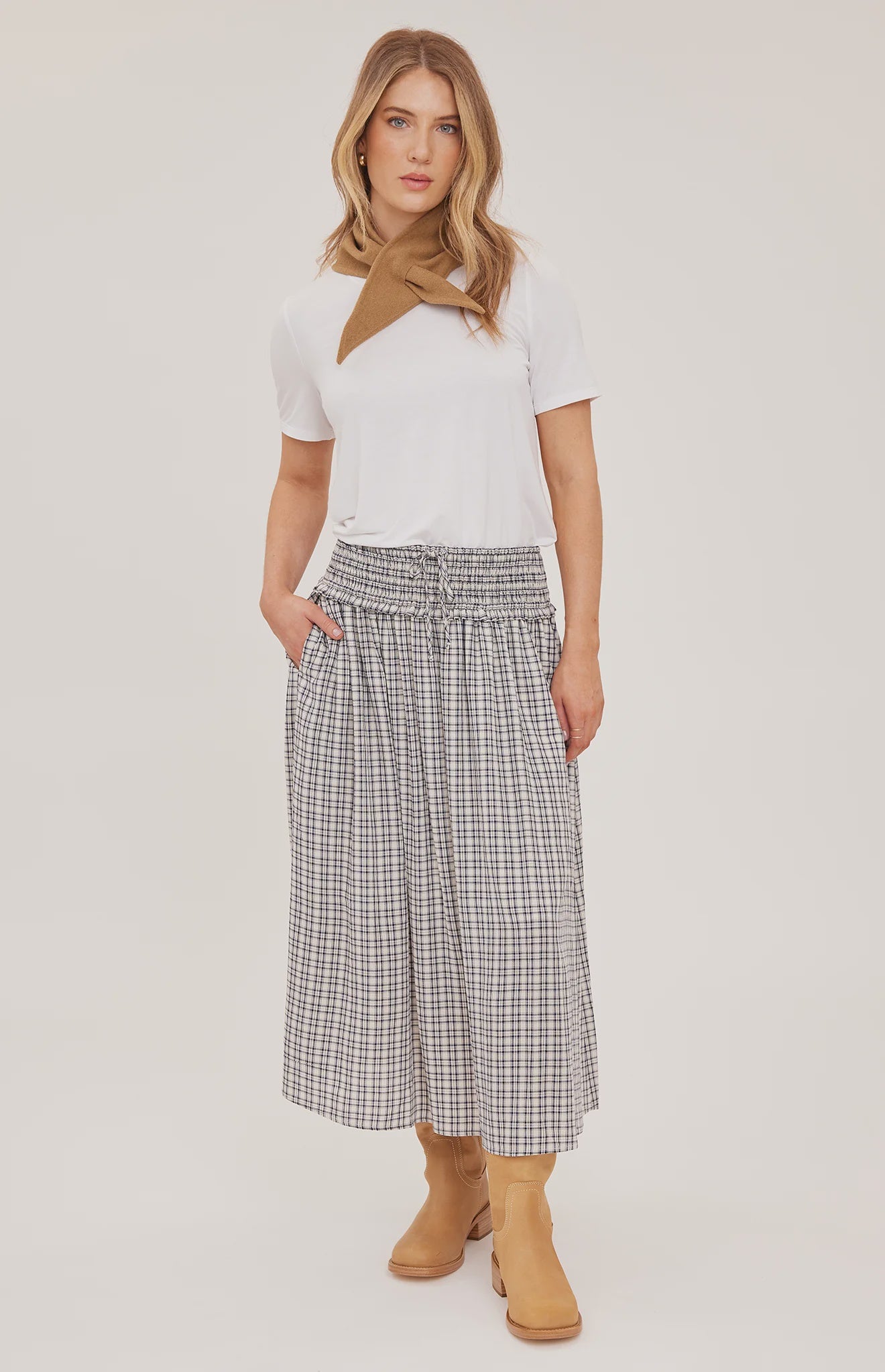 Women's black maxi skirt in a lightweight mini check fabric featuring a smocked high-rise waistband, flowing silhouette, inseam pockets, and a partially lined design 