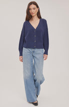 Woman wearing the Gentle Fawn Jennalee Cardigan in Navy, featuring an oversized fit, textured cotton blend knit, front button closure, and exposed seam detailing.