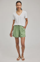 High-rise Juno shorts in a lightweight rayon-linen blend featuring an elastic drawstring waistband, front slash pockets, back patch pockets, and a relaxed fit.