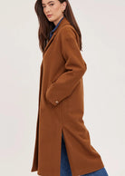 Agatha coat in soft, brushed melton fabric, featuring a front button closure, welt pockets, side slits, and a fully lined interior.