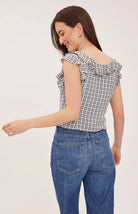 Women's black sleeveless tank top in a lightweight mini check fabric featuring a delicate flounce neckline, a relaxed fit, and a feminine silhouette.