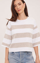 Woman wearing the Gentle Fawn Amina Knit Top in Heather Cream Stripe, featuring a relaxed fit, crew neckline, rolled hem details, and soft beige and cream horizontal stripes.