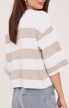 Woman wearing the Gentle Fawn Amina Knit Top in Heather Cream Stripe, featuring a relaxed fit, crew neckline, rolled hem details, and soft beige and cream horizontal stripes.