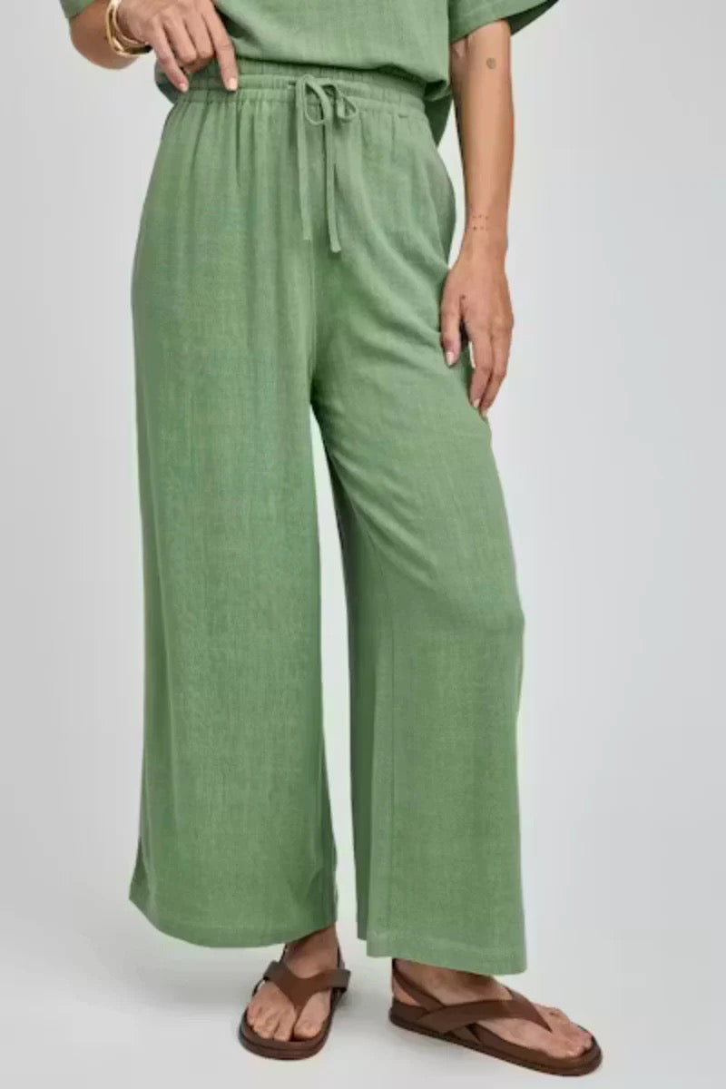Person wearing green wide-leg pants on a white background