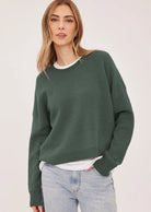 Axel oversized sweater in a soft waffle-knit yarn, featuring a crew neckline, exposed seam details, and side slits for a relaxed, textured look.