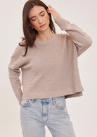 Axel oversized sweater in a soft waffle-knit yarn, featuring a crew neckline, exposed seam details, and side slits for a relaxed, textured look.