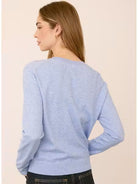 Woman wearing the Gentle Fawn Carina Sweater in Heather Blue, featuring a regular fit with a soft, lightweight knit in a classic light blue shade.