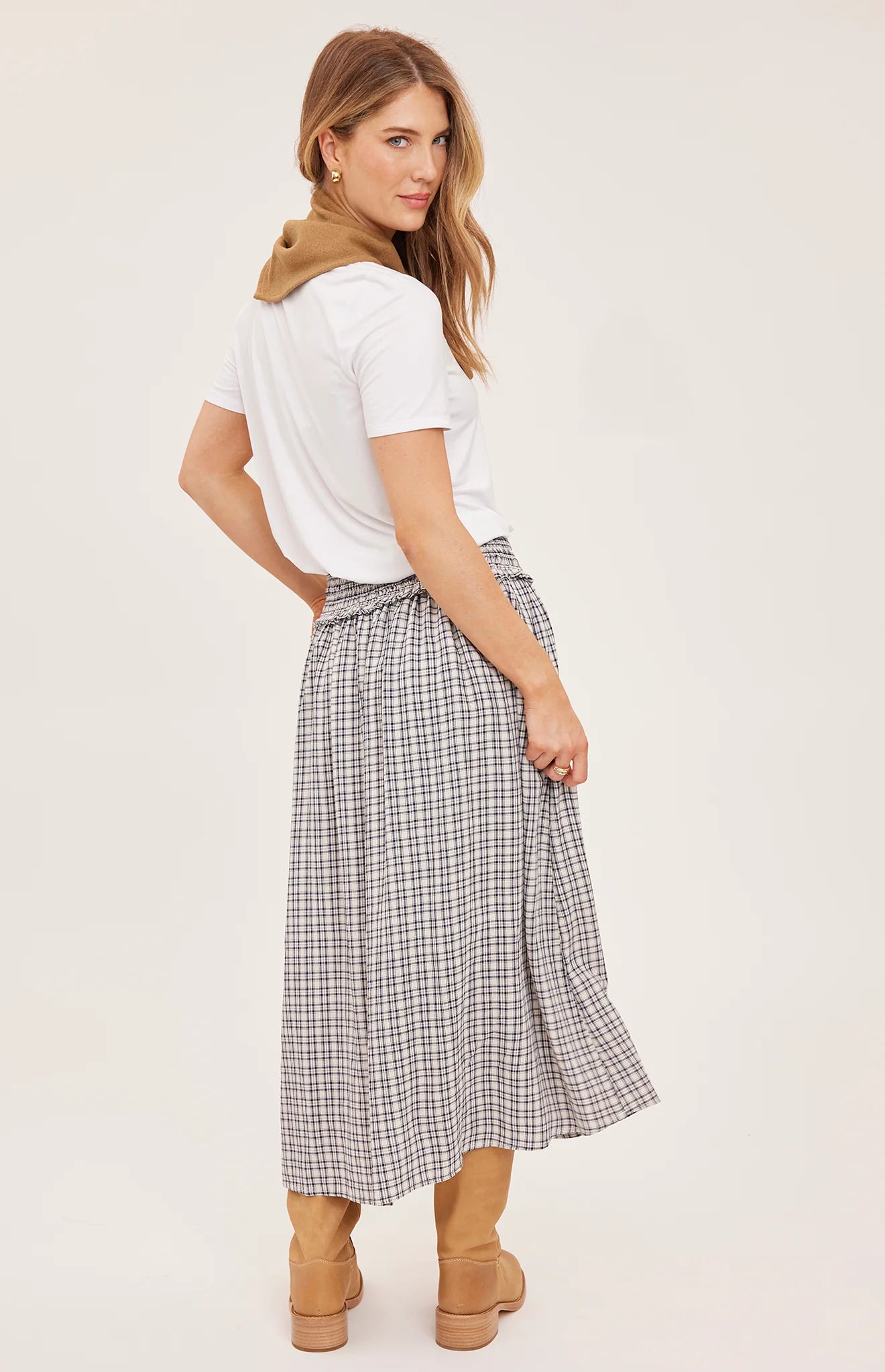 Women's black maxi skirt in a lightweight mini check fabric featuring a smocked high-rise waistband, flowing silhouette, inseam pockets, and a partially lined design 